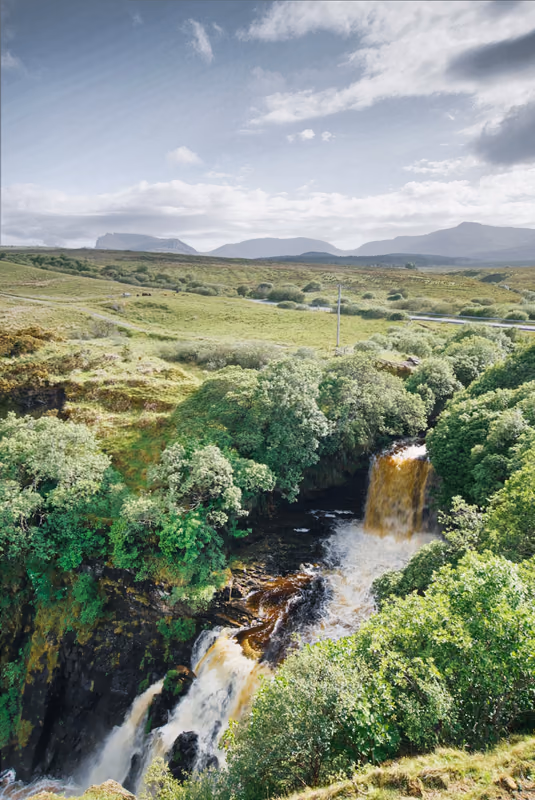 Wasserfall in schottischer Hochlandlandschaft, weite Bergkulisse